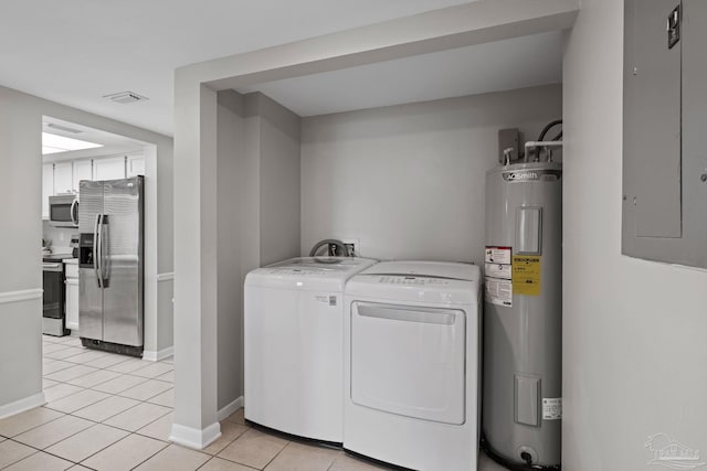 washroom featuring water heater, washing machine and dryer, electric panel, light tile patterned flooring, and baseboards