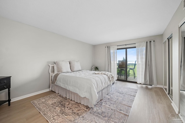 bedroom with light wood finished floors, access to outside, and baseboards