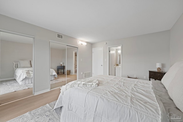bedroom with wood finished floors, connected bathroom, and baseboards