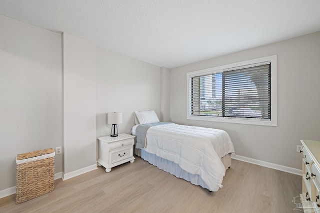 bedroom featuring light wood-style floors and baseboards