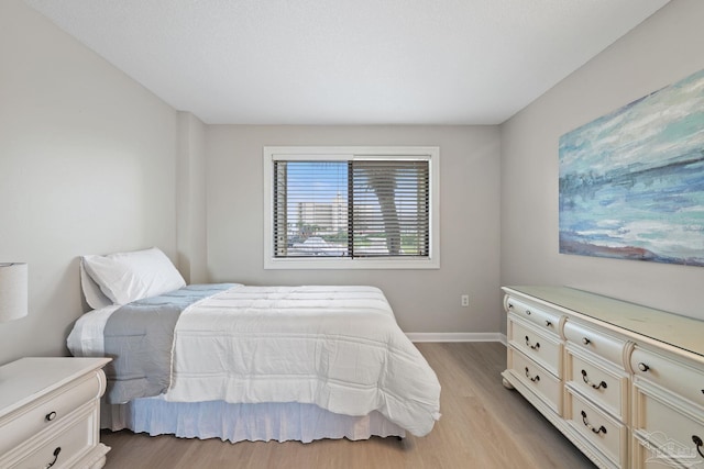 bedroom with light wood-style floors and baseboards