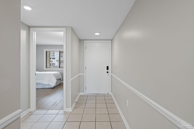 corridor with light tile patterned floors and baseboards