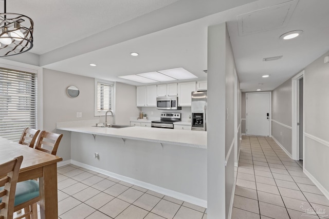 kitchen featuring stainless steel appliances, a sink, light tile patterned floors, light countertops, and recessed lighting