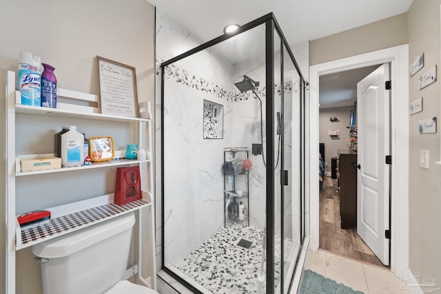 full bathroom featuring toilet and a marble finish shower