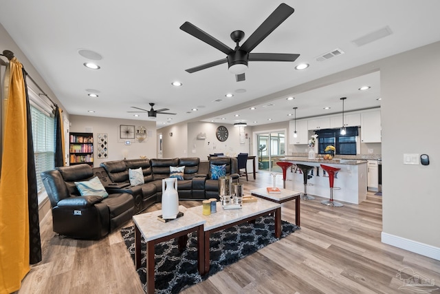 living room with visible vents, baseboards, recessed lighting, ceiling fan, and light wood-style floors