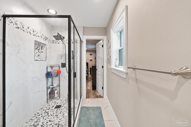 full bath featuring a marble finish shower, marble finish floor, and baseboards