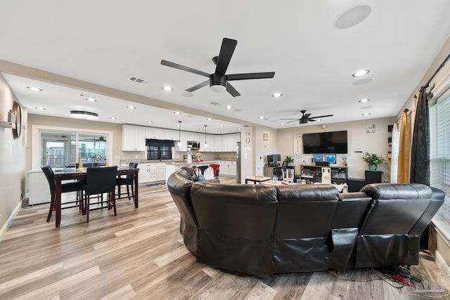 living area with visible vents, baseboards, recessed lighting, light wood-style flooring, and a ceiling fan