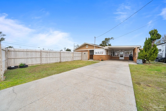 view of front of property featuring an attached carport, concrete driveway, a front lawn, and fence