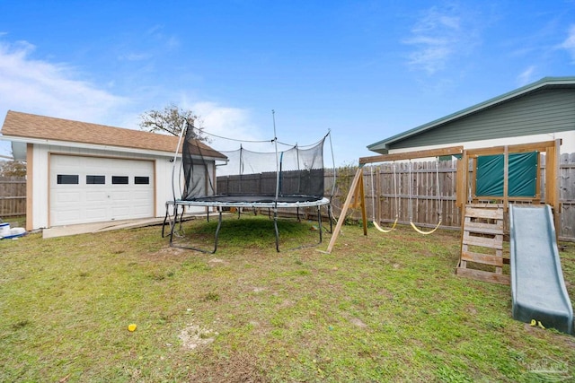 view of yard featuring a garage, a trampoline, a fenced backyard, and a playground