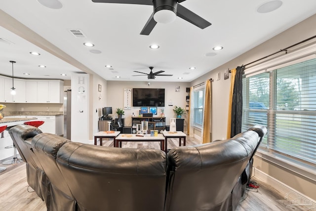 living room featuring recessed lighting, light wood-type flooring, and visible vents