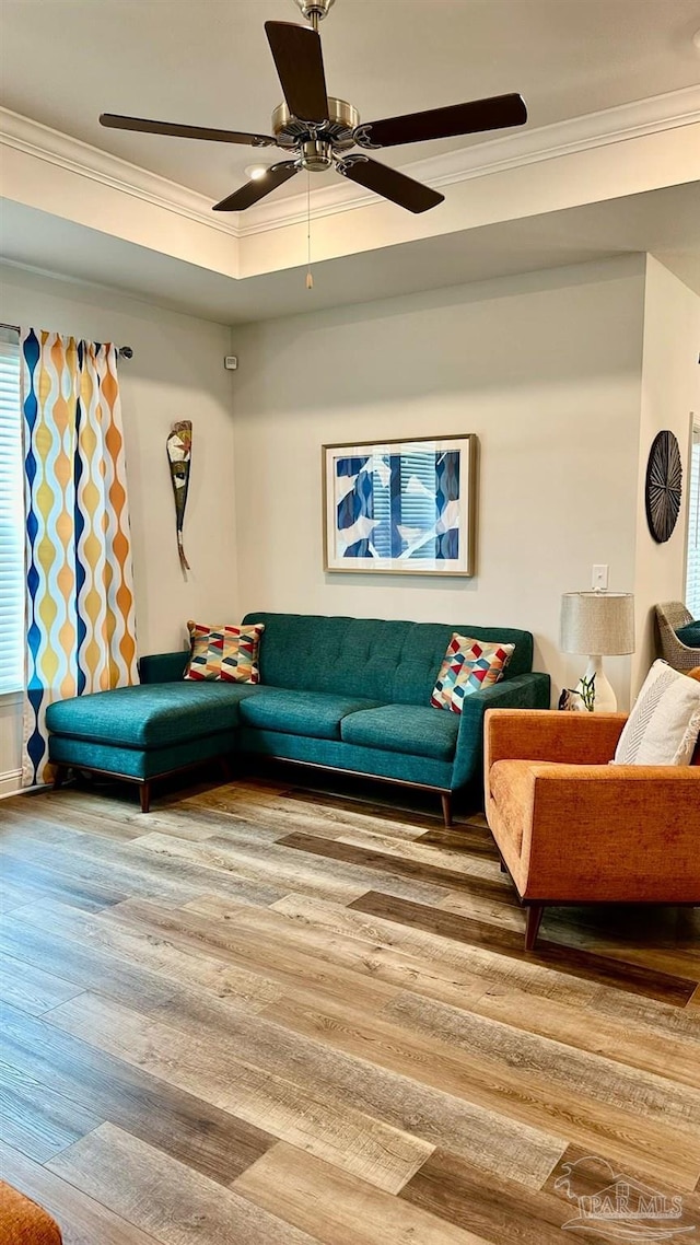 living room with hardwood / wood-style floors, ceiling fan, and ornamental molding