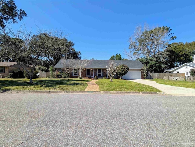 ranch-style home featuring an attached garage, brick siding, fence, driveway, and a front lawn