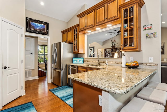 kitchen featuring a kitchen breakfast bar, kitchen peninsula, sink, and stainless steel appliances