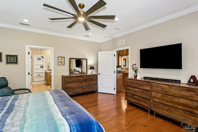 bedroom featuring ceiling fan, wood-type flooring, crown molding, and connected bathroom