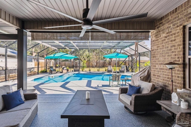 view of swimming pool with glass enclosure, ceiling fan, and a patio area