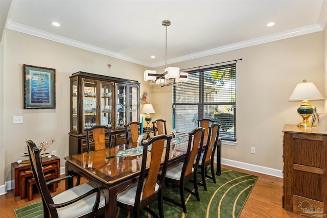 dining area featuring a notable chandelier, wood-type flooring, and crown molding