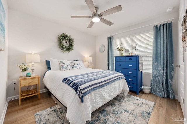 bedroom with light wood-style floors, ceiling fan, and baseboards