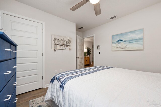 bedroom with dark wood-style floors, visible vents, and a ceiling fan