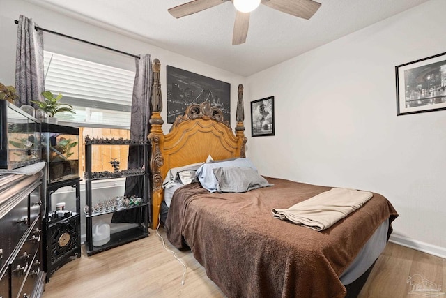 bedroom featuring ceiling fan, wood finished floors, and baseboards