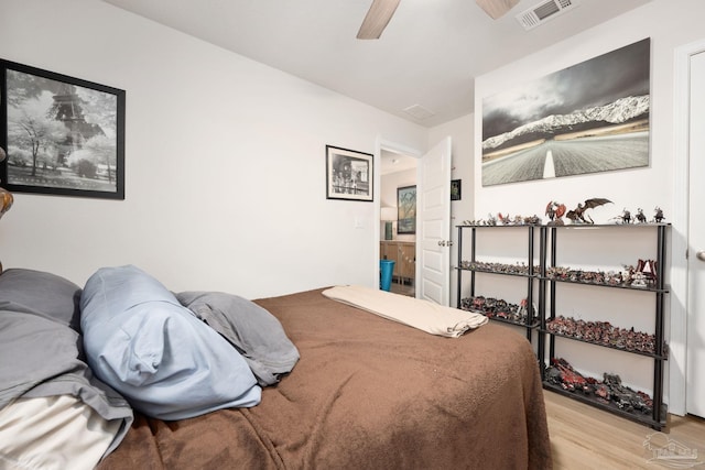 bedroom featuring light wood-style flooring, visible vents, and a ceiling fan