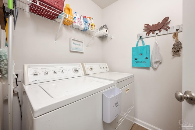 laundry area featuring laundry area, washing machine and clothes dryer, and baseboards