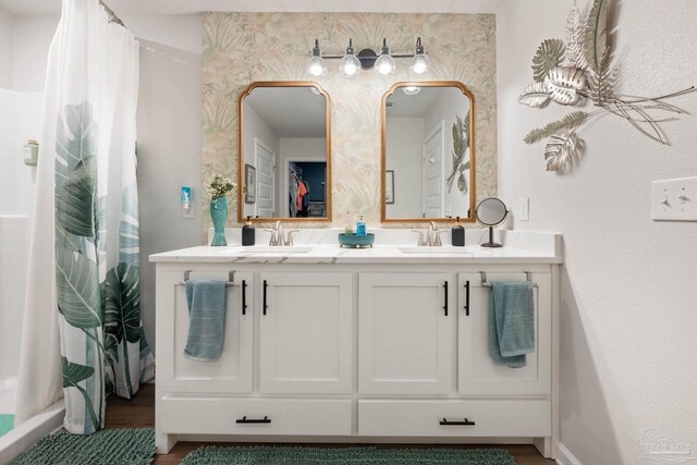 full bathroom featuring a shower with curtain, wood finished floors, a sink, and double vanity