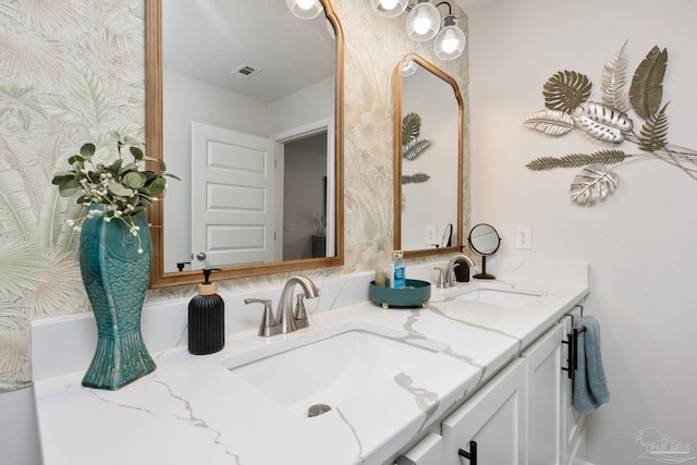 full bath featuring visible vents, a sink, and double vanity