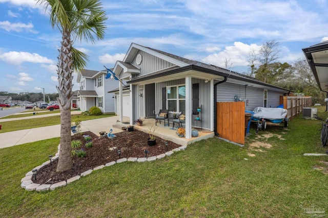 view of front of house featuring concrete driveway, a front lawn, and central AC