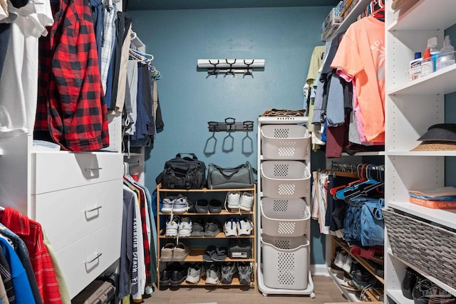 walk in closet with wood finished floors