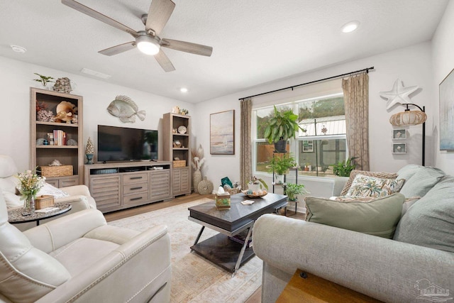 living area featuring ceiling fan, a textured ceiling, light wood-style flooring, and recessed lighting