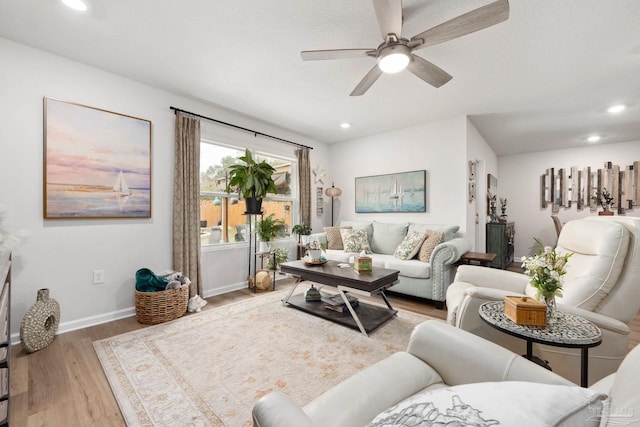 living room featuring a ceiling fan, recessed lighting, baseboards, and wood finished floors