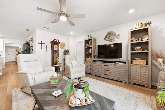 living area with light wood-style floors, visible vents, and a ceiling fan