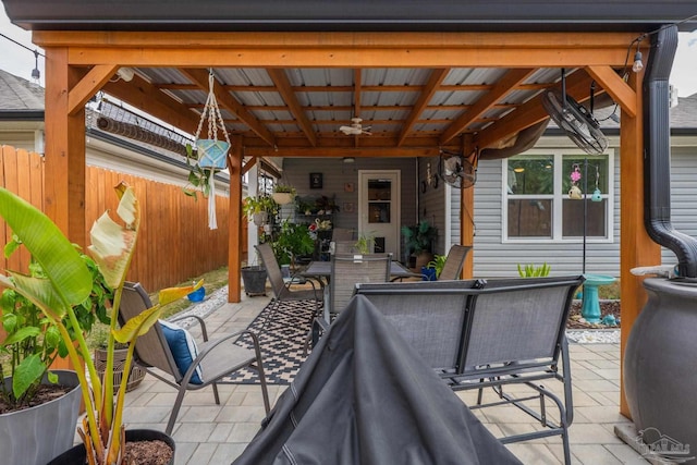 view of patio featuring outdoor dining space, fence, and ceiling fan