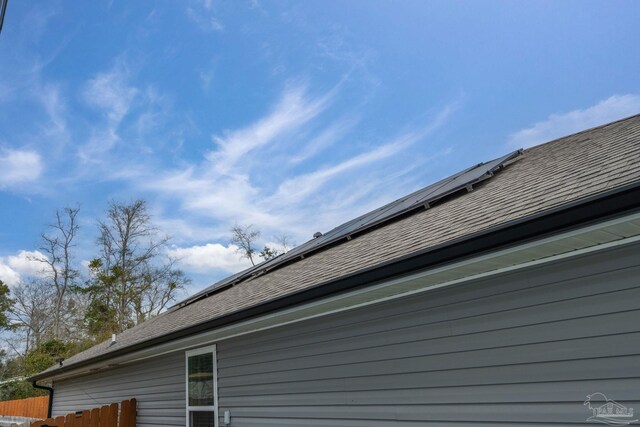 exterior details with gutters, a shingled roof, a downspout, and fence