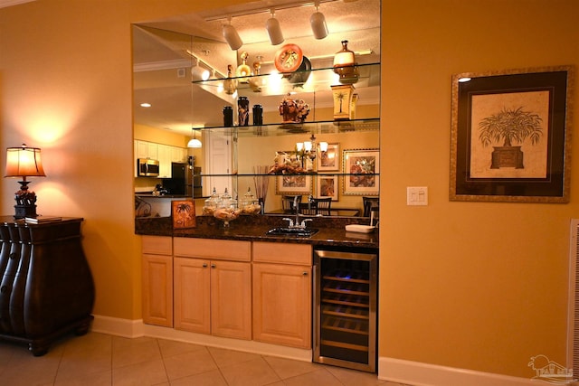 bar featuring wine cooler, dark stone counters, black refrigerator, light tile patterned floors, and ornamental molding