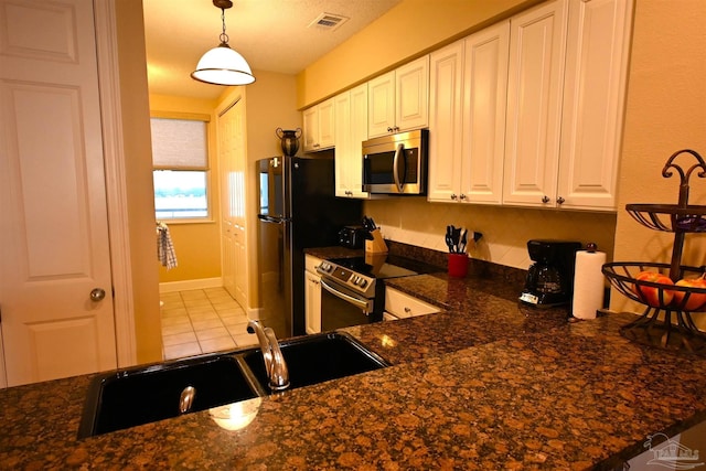 kitchen with pendant lighting, white cabinets, sink, appliances with stainless steel finishes, and kitchen peninsula