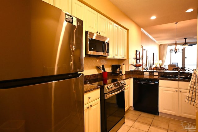 kitchen featuring kitchen peninsula, a chandelier, white cabinets, and stainless steel appliances