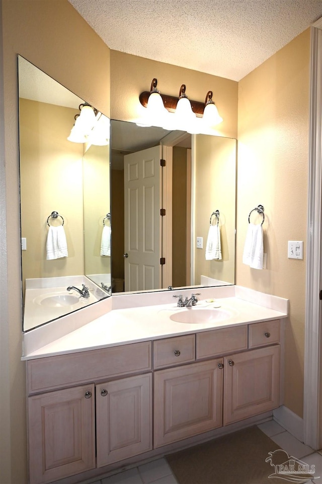 bathroom with tile patterned floors, vanity, and a textured ceiling