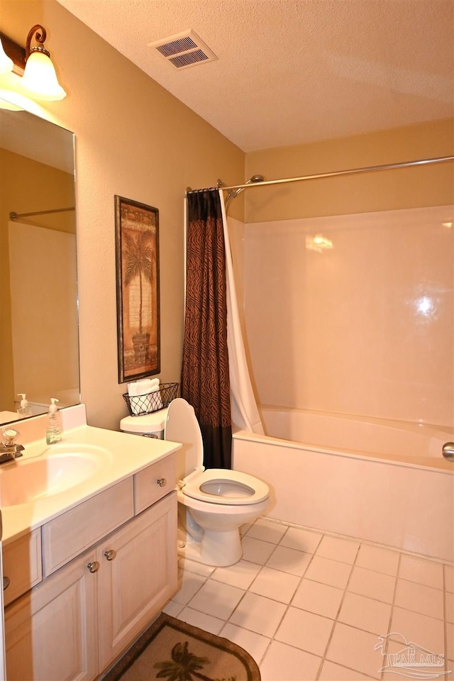 full bathroom with tile patterned floors, vanity, shower / bath combo with shower curtain, and a textured ceiling