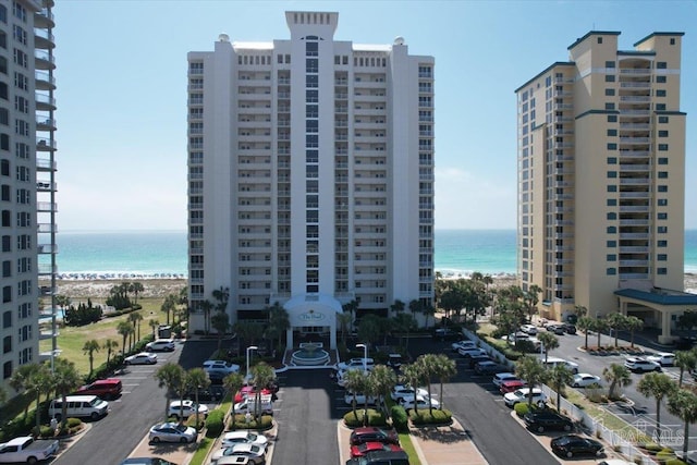 view of building exterior featuring a water view and a beach view