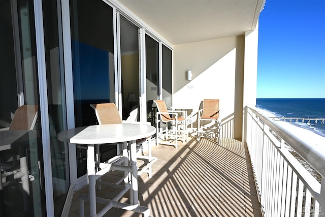 balcony featuring a water view and a beach view