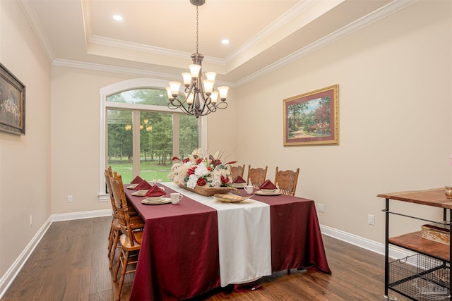 dining space featuring ornamental molding, a chandelier, a raised ceiling, and dark wood-type flooring