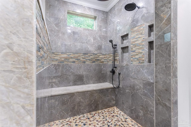 bathroom featuring crown molding and a tile shower