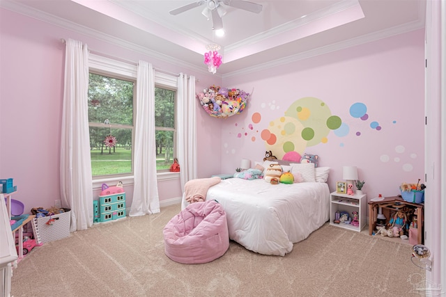 bedroom with ceiling fan, crown molding, light colored carpet, and a tray ceiling