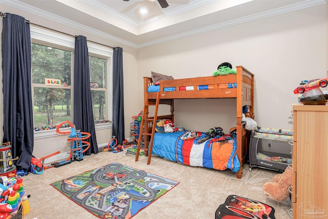 bedroom featuring a raised ceiling, crown molding, carpet floors, and ceiling fan