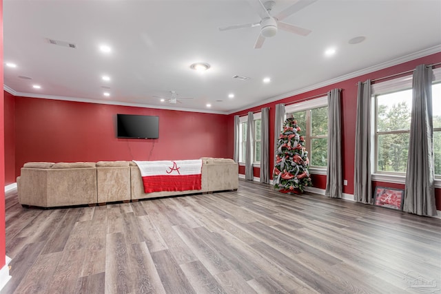 unfurnished living room with ornamental molding, ceiling fan, and light wood-type flooring