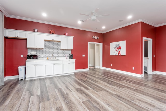 kitchen with white cabinetry, ceiling fan, decorative backsplash, ornamental molding, and light hardwood / wood-style flooring