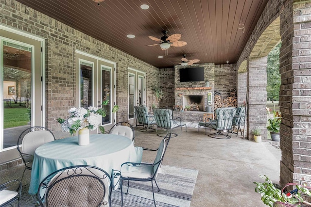 view of patio / terrace featuring an outdoor stone fireplace and ceiling fan