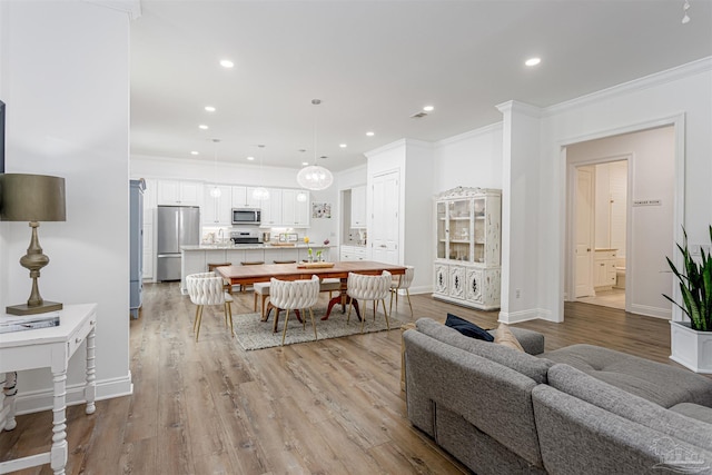 living room with light wood-type flooring and ornamental molding