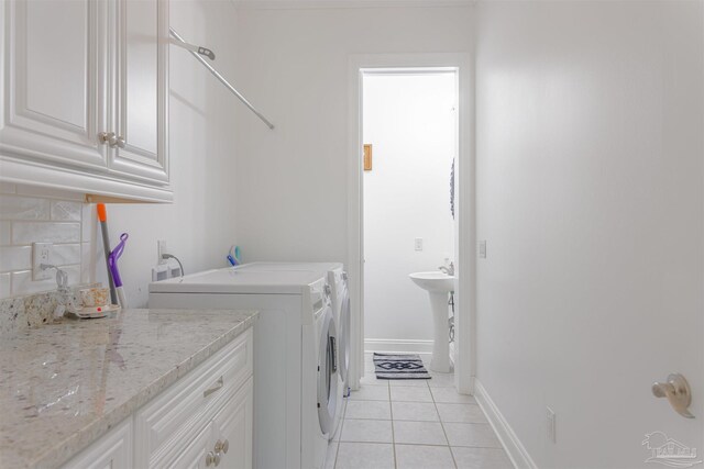 9180 Chumuckla Hwy, Pace, FL 32571 - laundry room with light tile patterned floors, baseboards, cabinet space, and independent washer and dryer